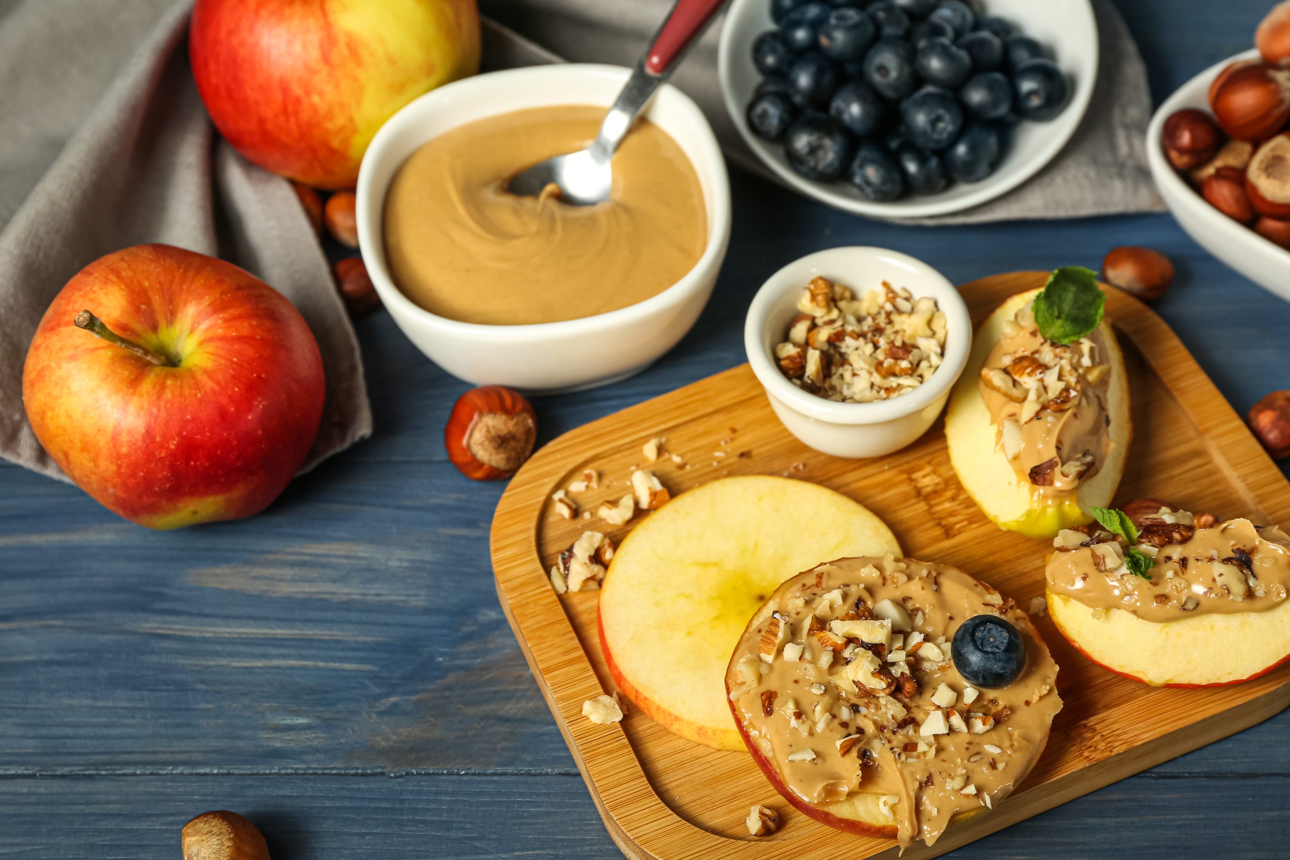 Apfelscheiben mit Erdnussbutter und Nüssen